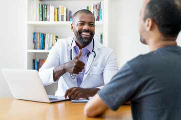 Obraz premium Mature adult african american male doctor talking to patient