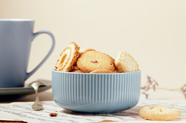 Close up of Cookies on blue cup on light spring background with vintage paper. Spring theme.
