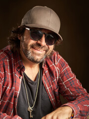 portrait of a happy man with cap and sunglasses smiling and looking at the camera