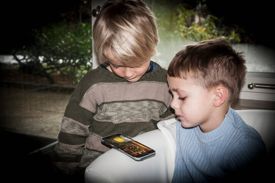 Two boys using smart phone at home