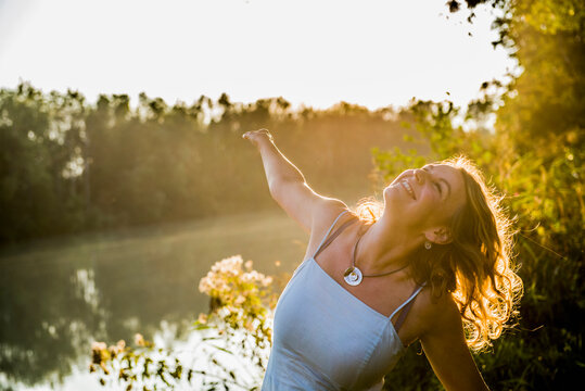 Happy beautiful woman outside at a river looking up