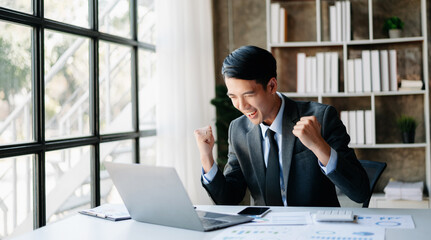 Asian businessman are delighted and happy with the work they do on their tablet, laptop and taking notes at the office.