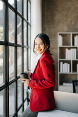 Young attractive Asian female office worker business suits smiling at camera in office