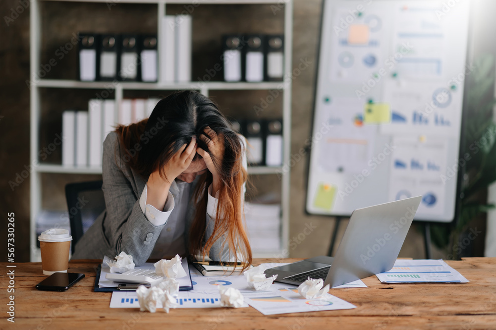 Wall mural Woman who is tired and overthinking from working with tablet and laptop at modern office...