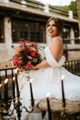 Beautiful bride with her bouquet sititng in the stone garden