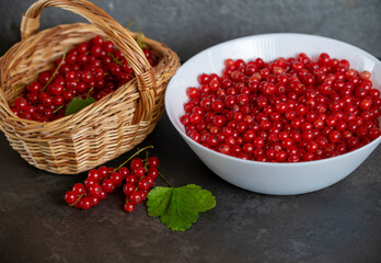 a basket of fresh red currants stands on a dark table