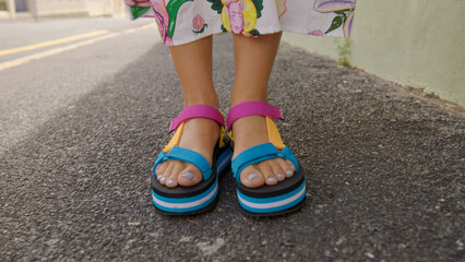 Front view of woman's feet in multi-color sandals on the street