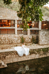 Dreamy portraits of beautiful bride on stone riverbank