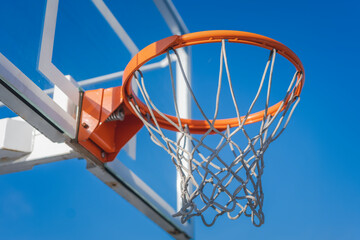 Basketball basket against the blue sky, sports ground in the city concept