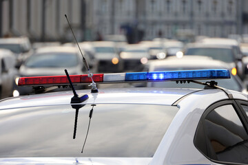 Flashing lights on police car against the city street. Violation of traffic rules, road accident