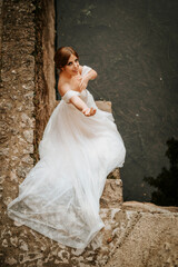 Dreamy portraits of beautiful bride on stone riverbank