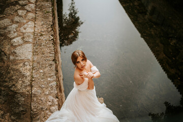 Dreamy portraits of beautiful bride on stone riverbank