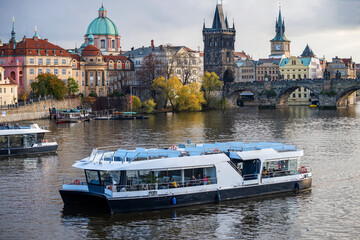 Boat on river, ancient building and embankment, Prague.