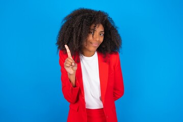 No sign gesture. Closeup portrait unhappy young businesswoman with afro hairstyle wearing red over...