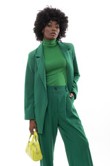 Fashionable brunette with green suit and handbag on isolated white background.