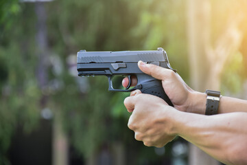 9mm automatic pistol holding in right hand of shooter at the shooting range, concept for security,...