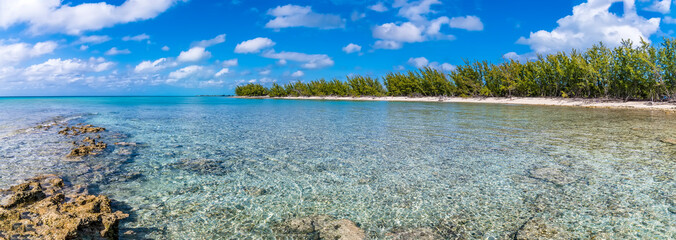 A panorama view from a rocky headland across a deserted bay on the island of Eleuthera, Bahamas on a bright sunny day