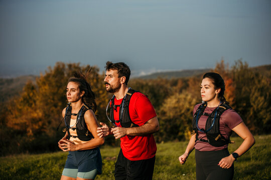 Three runners sprinting outdoors - Sportive people training in a nature area, healthy lifestyle, and sports concepts. High quality photo