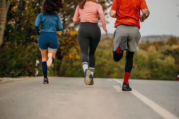 Rear view of a fitness sports people running lifestyle concept. Group of dedicated young people jogging together outdoors