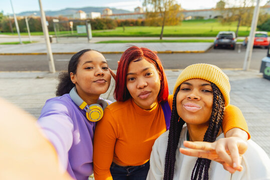 Three latina girls taking a selfie on the street. Women with unretouched skin. celebrating friendship.