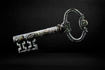 Detailed vintage key on a black background in moody light. Fine art photography - 567349431