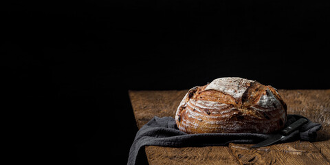 Rustic crispy sourdough bread with cranberries on a wooden table. Panoramic view, free space for text