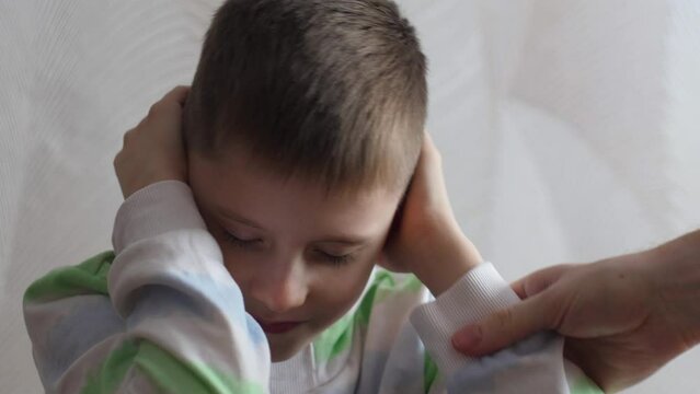 caucasian boy ignores the anger of his parents by closing his eyes and ears with his hands .naughty teenager. parenting concept, transitional age in boys