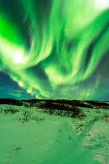 Fototapeta na wymiar imagen de una aurora boreal iluminando el cielo nocturno de Islandia con el paisaje nevado 