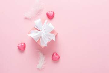 A mock-up of a Valentine's Day banner with a gift box, heart-shaped candies on a pink background.