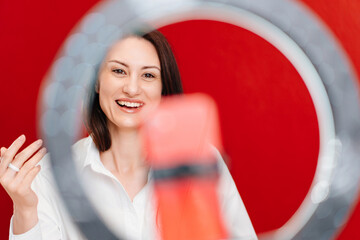 a brunette woman works at the computer and conducts a live broadcast 
