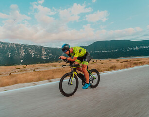 Full length portrait of an active triathlete in sportswear and with a protective helmet riding a...