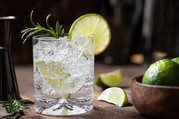 Gin and tonic cocktail with lime. rosemary and ice - obrazy, fototapety, plakaty