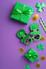 Saint Patrick's Day concept. Top view vertical photo of green gift boxes hat shaped party glasses gold coins straws and clovers on isolated lilac background