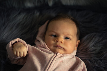 portrait eines süßen babys auf einer grauen felldecke liegend