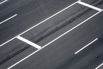 Top view of asphalt road with white strips.