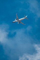 Airline plane over light blue sky with few clouds.
Plane view in full takeoff.