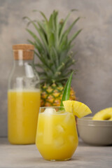 Pineapple cocktail in glass jars on wooden table closeup
