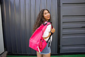 Cheerful Young Indian woman wearing trendy pink backpack.lifestyle fashion portrait. College student. Copy Space.