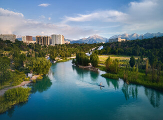Man ride on SUP board in the mountain lake in city