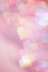 Defocused abstract bokeh background with pink pastel colored hearts, flare from lights, blurred bokeh holiday, celebration wallpaper. love and romance aesthetic photo, glittering lights pattern