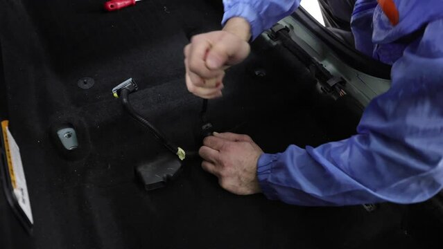 Sound-insulated car soundproofing auto repair. Removing and dismantling vehicle upholstery. A worker is trying to remove a car upholstery.