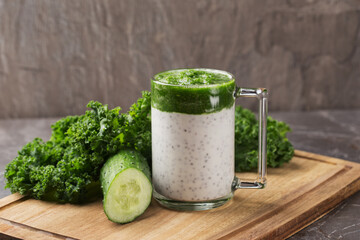 Chia seed pudding with curly kale, cucumber in glass on dark table. Healthy breakfast. Clean eating and superfoods concept. Organic food.