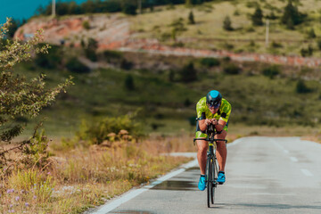 Full length portrait of an active triathlete in sportswear and with a protective helmet riding a...