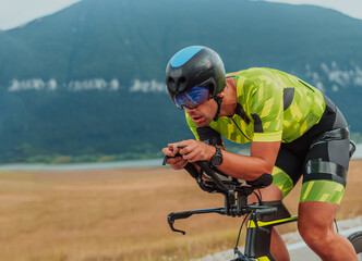 Full length portrait of an active triathlete in sportswear and with a protective helmet riding a...