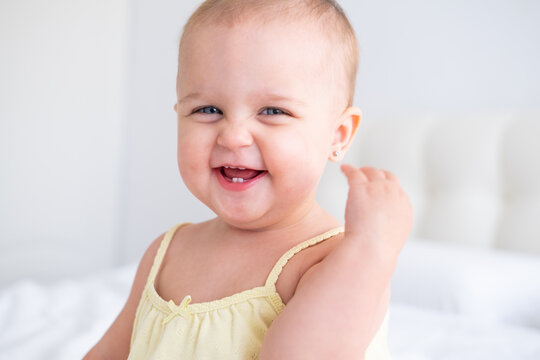 portrait of cute baby girl smiling with first milk teeth. Healthy newborn child