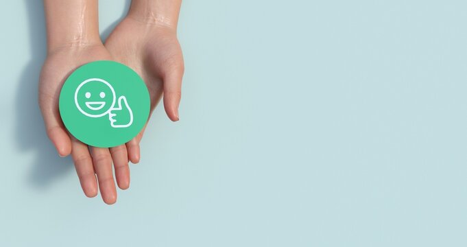 Hands holding green happy smile face paper cut, good feedback rating,think positive, customer review, assessment, child wellness,world mental health day, Compliment Day