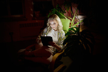 Battery powered lamp light. Young beautiful woman sitting in dark room with laptop at home in the...