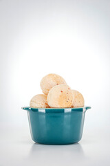 Isolated cheese breads in two green ramekins on white background.