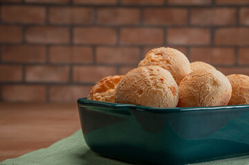 Cheese breads in a serving dish on a bricks wall background.