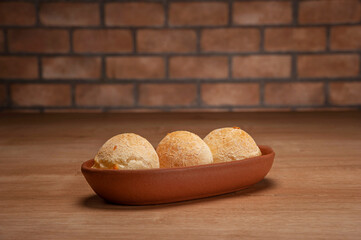 Cheese breads on serving dish on bricks wall background.